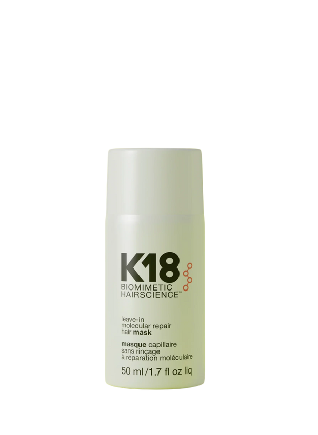 A bottle of K18 Leave-In Molecular Repair Hair Mask on a yellow background.