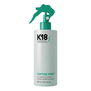 K18 Peptide Prep bottle with spray nozzle on a teal background