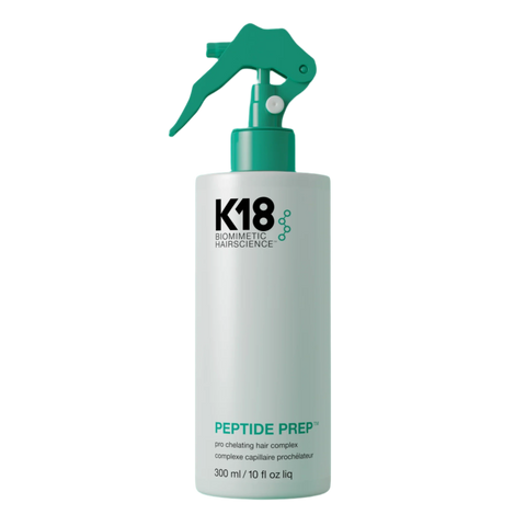 K18 Peptide Prep bottle with spray nozzle on a teal background