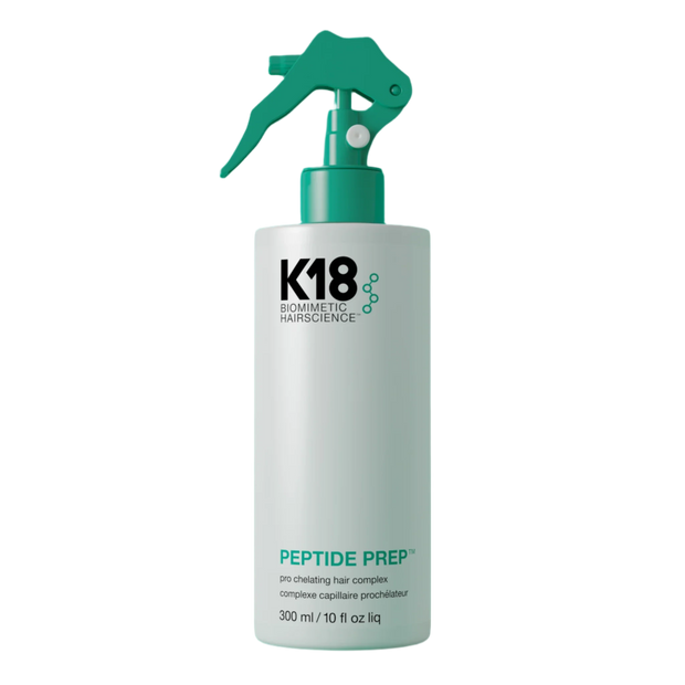 K18 Peptide Prep bottle with spray nozzle on a teal background