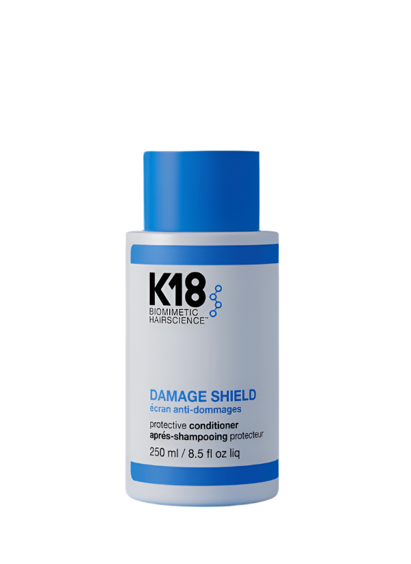 K18 Damage Shield conditioner bottle on a blue background