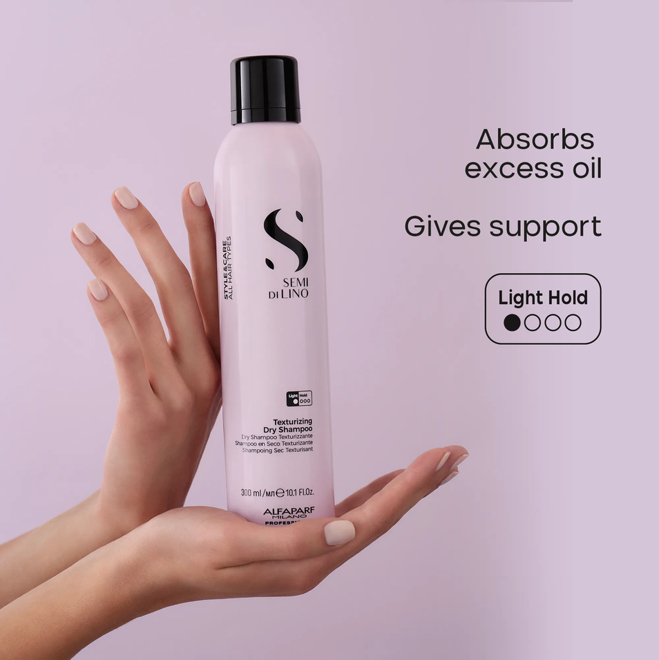 A hand holds a bottle of SEMI DE LINO Texture Dry Shampoo against a light purple background, with promotional text on the right detailing its oil-absorbing properties and light hold texture.