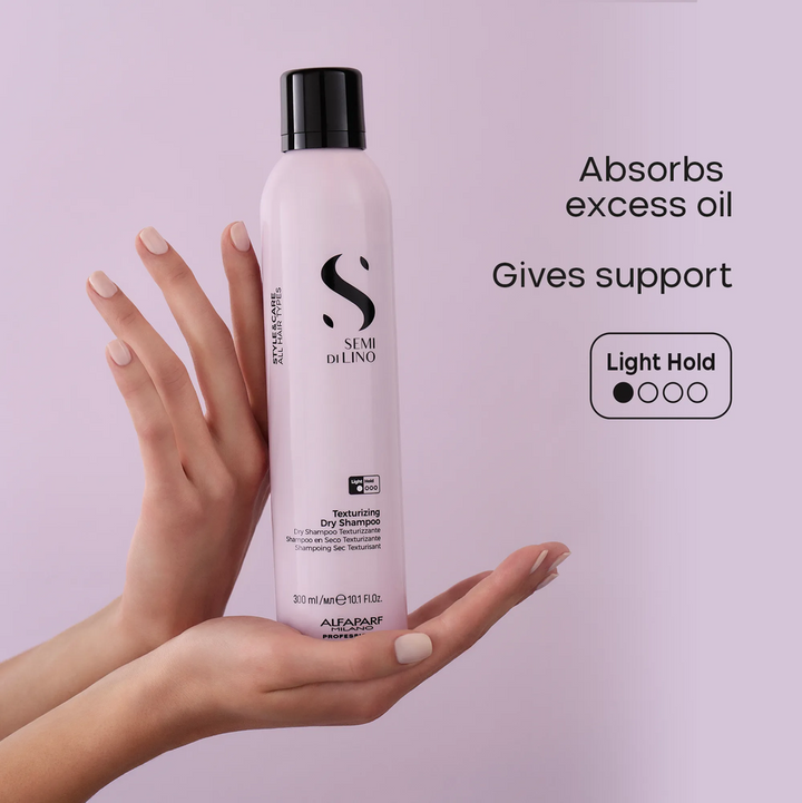 A hand holds a bottle of SEMI DE LINO Texture Dry Shampoo against a light purple background, with promotional text on the right detailing its oil-absorbing properties and light hold texture.