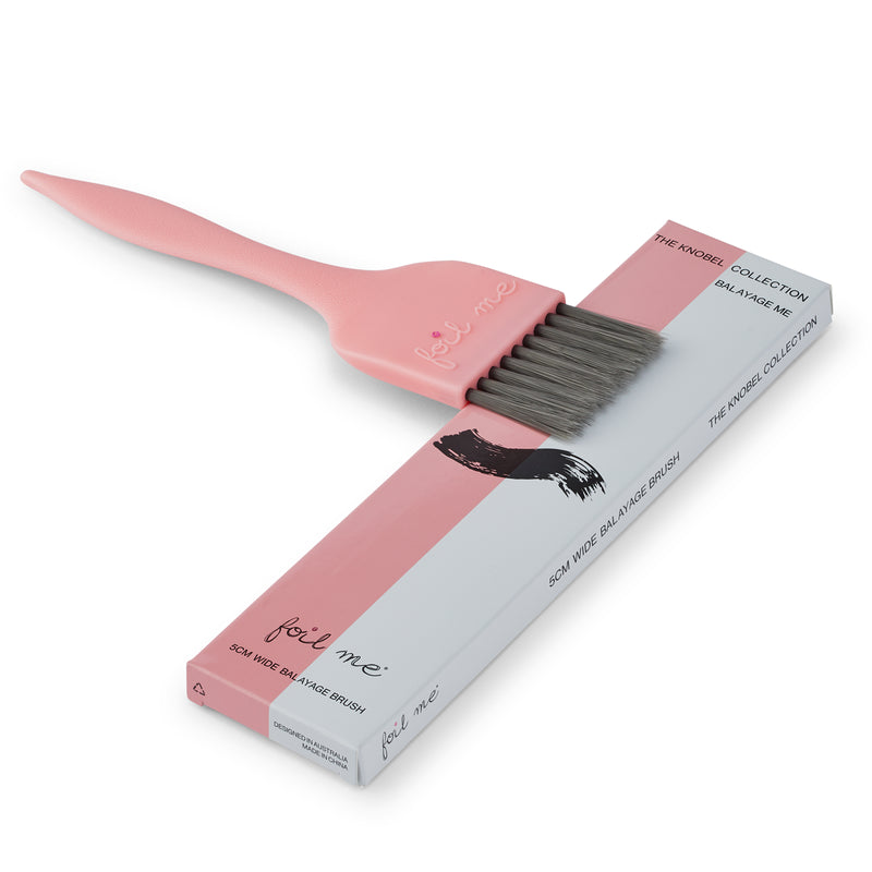 Pink tint brush with black bristles and packaging on a white background
